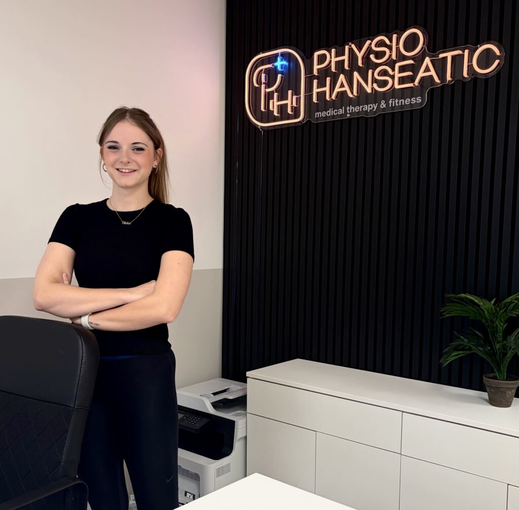 Paula Fricke vor dem Logo von Hanseatic Physio
